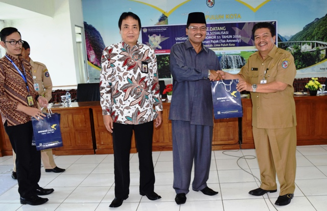 Bupati Limapuluh Kota Irfendi Arbi menyerahkan cenderamata kepada peserta sosialisasi pelaksanaan pengampunan pajak (Tax`Amnesti) di aula kantor bupati setempat, Selasa (1/11).- Bupati Limapuluh Kota Irfendi Arbi menyerahkan cenderamata kepada pe